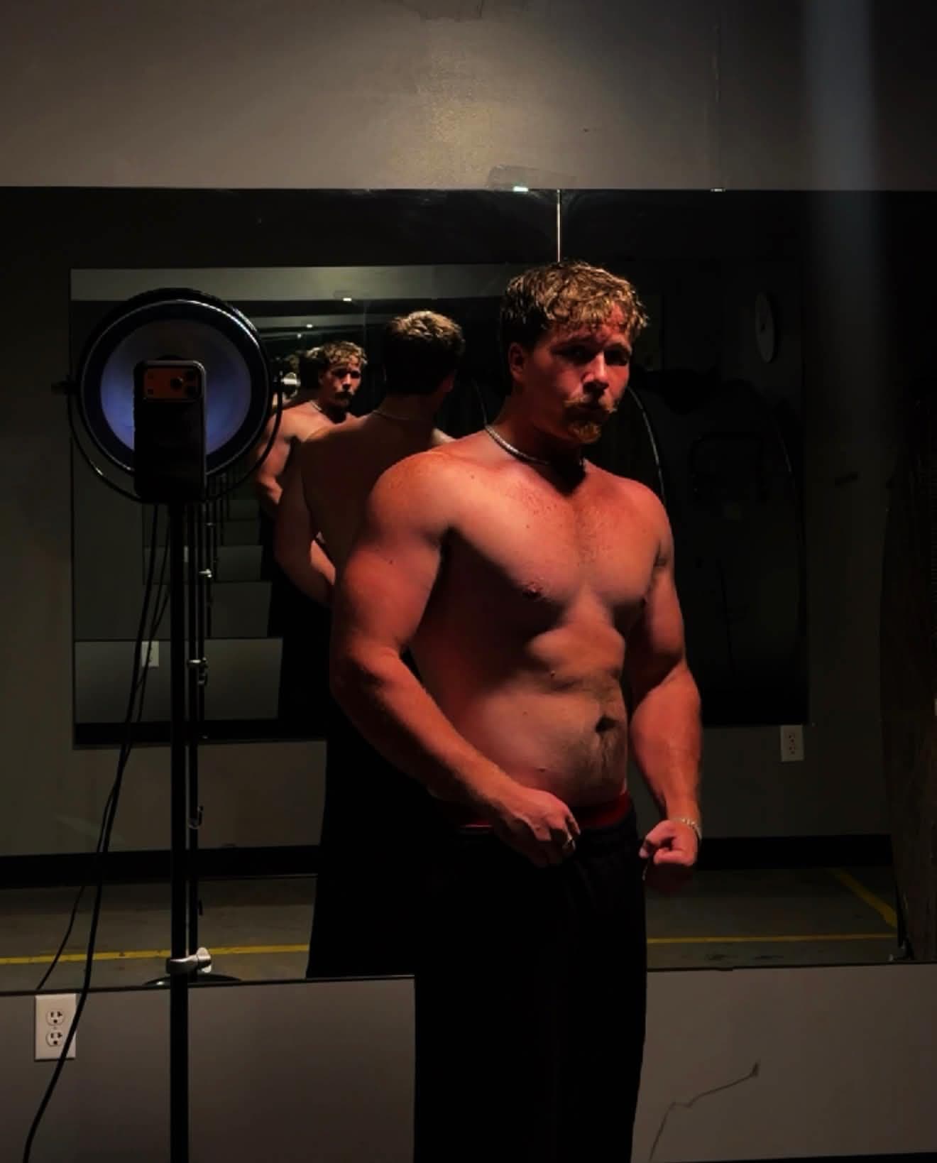 Layne after his physique transformation, taking a mirror progress photo