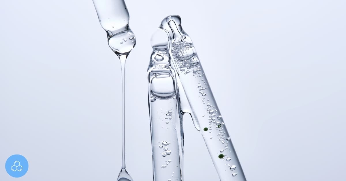 Clear laboratory ampoules and a dropper on a pale background